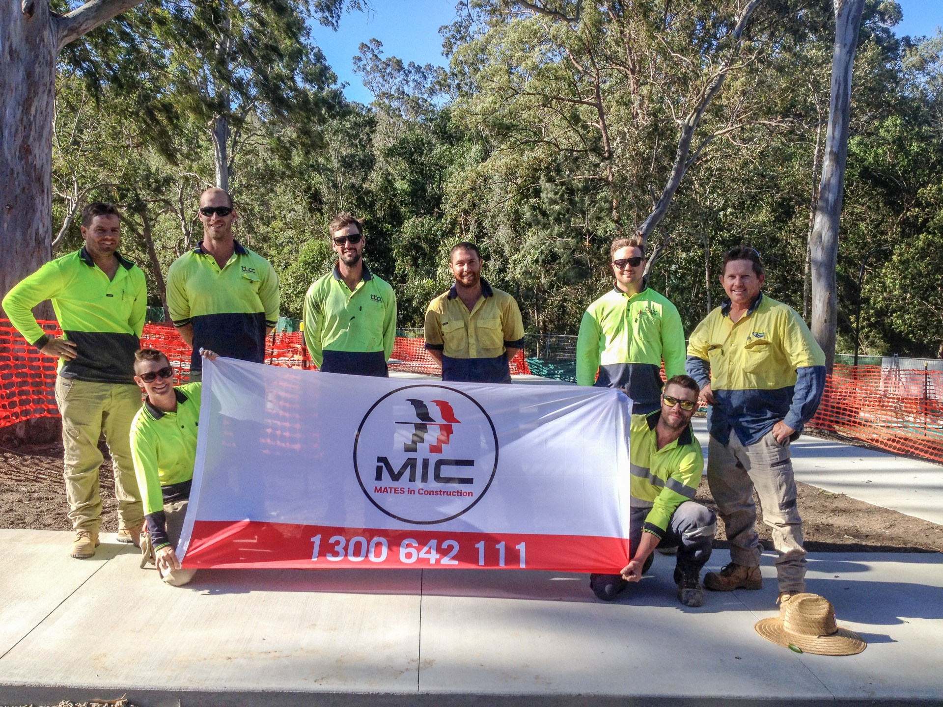 workers holding mates in construction banner